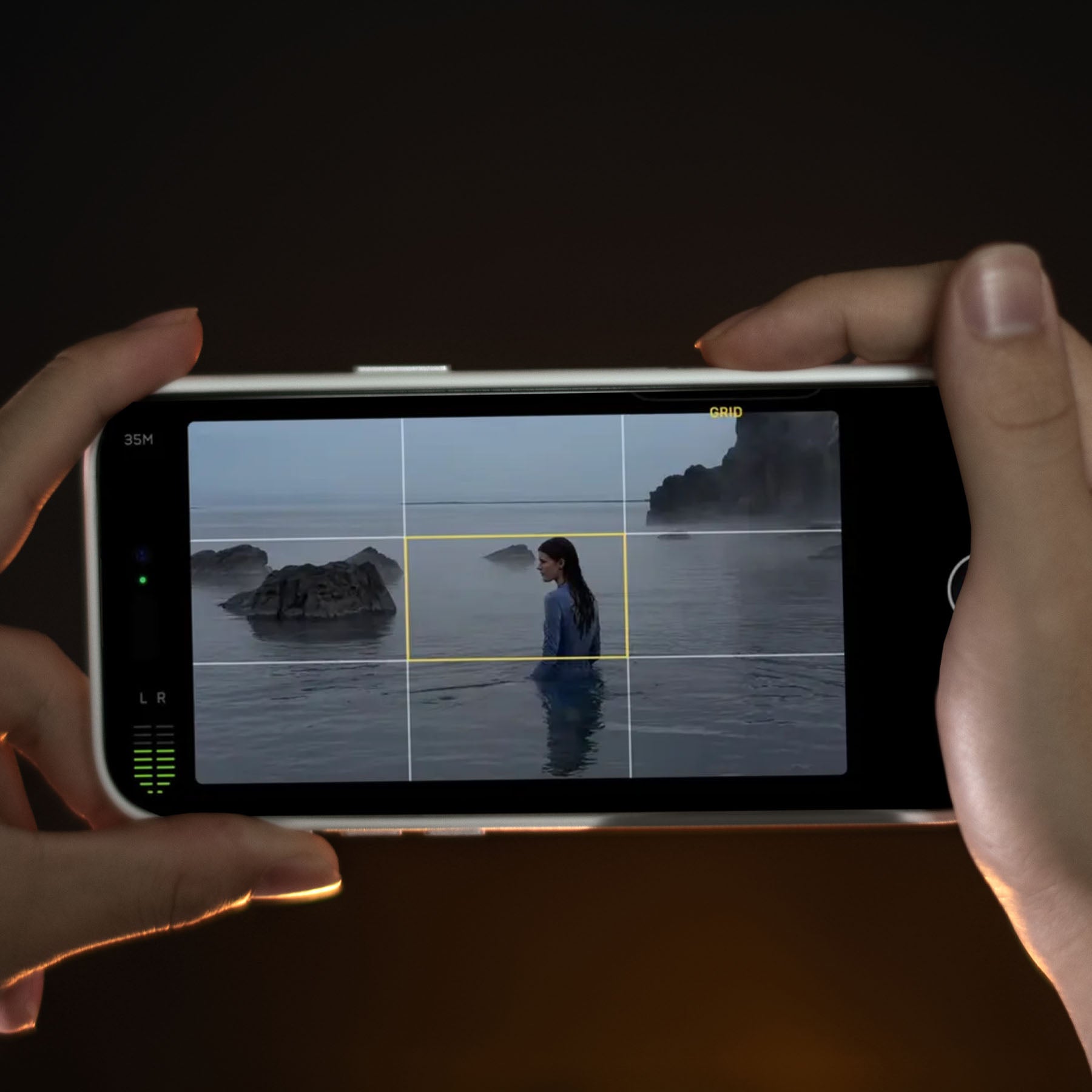 AULUMU A16 iPhone 16 Pro case in use, held horizontally while shooting video of a person in the sea with the camera control interface on screen