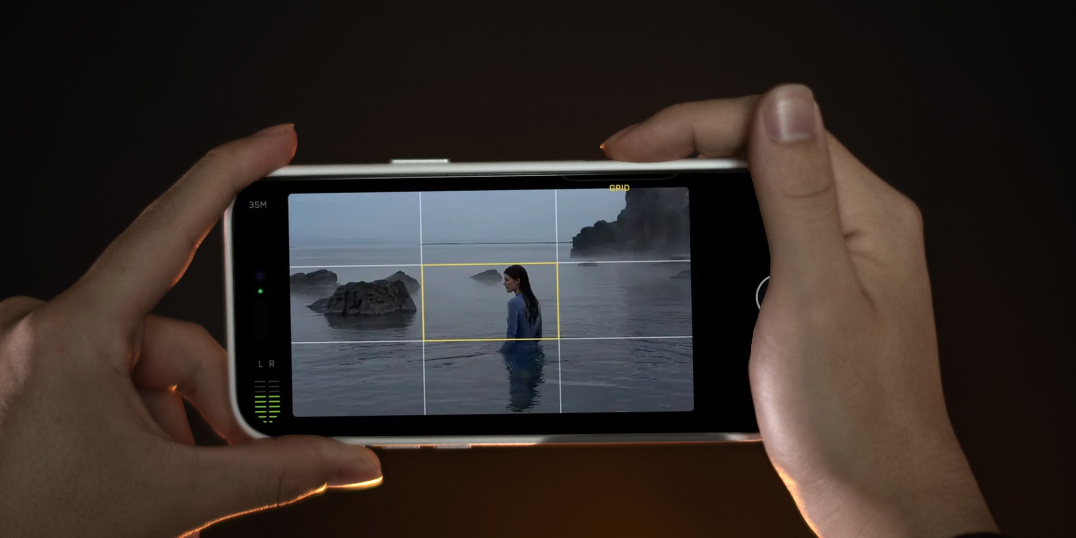 AULUMU A16 iPhone 16 Pro case in use, held horizontally while shooting video of a person in the sea with the camera control interface on screen