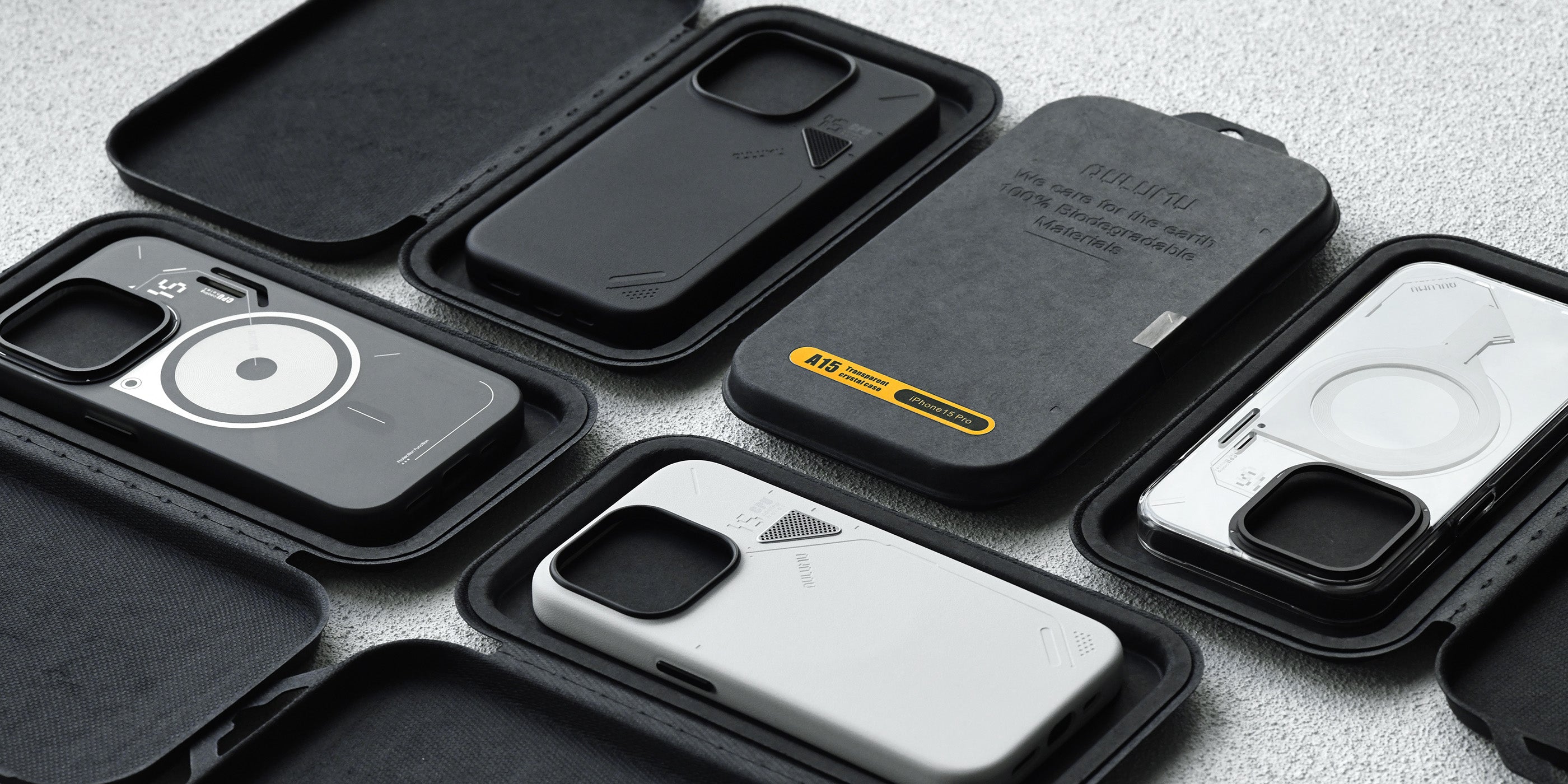 Assorted AULUMU A05 and related iPhone cases in black eco-friendly packaging on tabletop