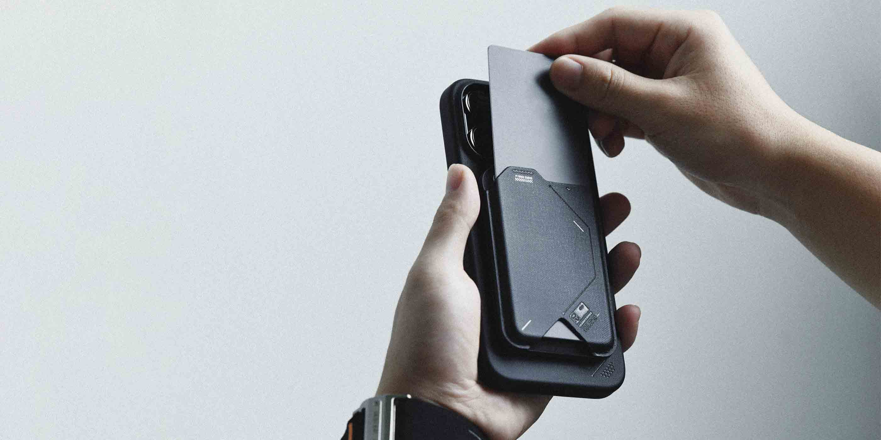 Person sliding a card into AULUMU G02 Magnetic Flip Wallet attached to the back of an iPhone.